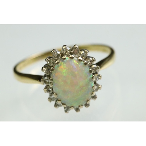 35 - Opal and diamond 18ct yellow and white gold set cluster ring, the precious white opal displaying vio... 