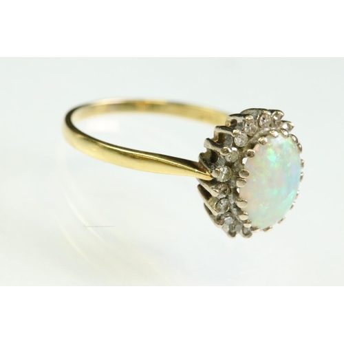 35 - Opal and diamond 18ct yellow and white gold set cluster ring, the precious white opal displaying vio... 