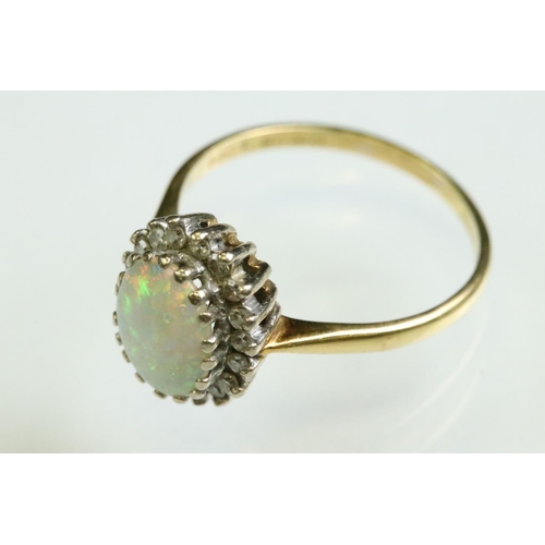 35 - Opal and diamond 18ct yellow and white gold set cluster ring, the precious white opal displaying vio... 