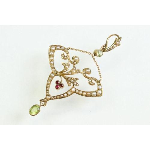 56 - Early 20th century peridot, ruby and seed pearl unmarked yellow gold pendant, the openwork trefoil f... 