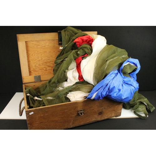 384 - A used parachute contained within a large wooden military box.