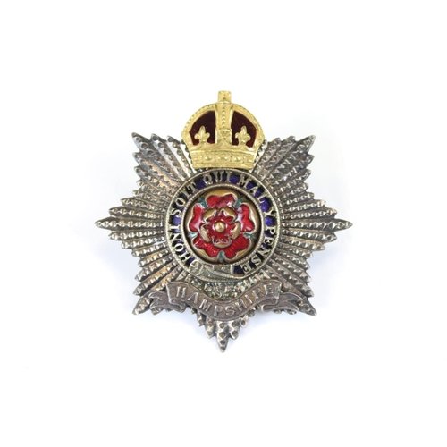 202 - A British Military The Hampshire Regiment Kings Crown Cap Badge With Enamel Decoration, Complete Wit... 