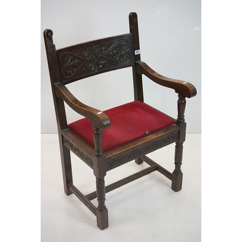 578 - In the manner of Liberty of London, Gothic Revival Oak Elbow Chair with carved back rail and upholst... 