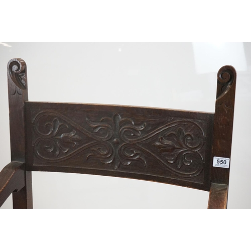 578 - In the manner of Liberty of London, Gothic Revival Oak Elbow Chair with carved back rail and upholst... 