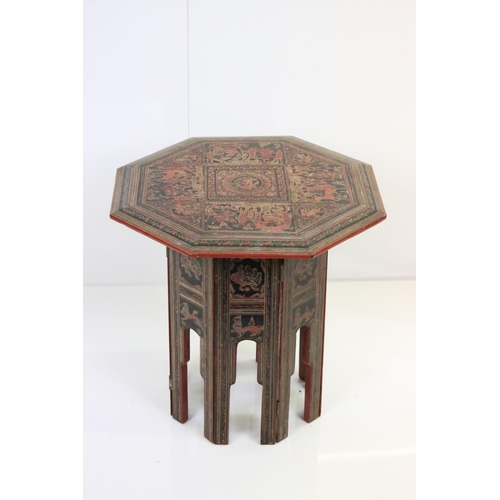 631 - Burmese Red and Black Lacquered Octagonal Folding Table decorated with images of figures, birds, ani... 