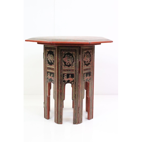 631 - Burmese Red and Black Lacquered Octagonal Folding Table decorated with images of figures, birds, ani... 