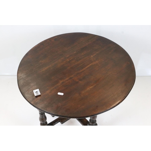 559 - Oak Circular Tilt Top Table in the 17th century style raised on a turned and block folding base, 56c... 