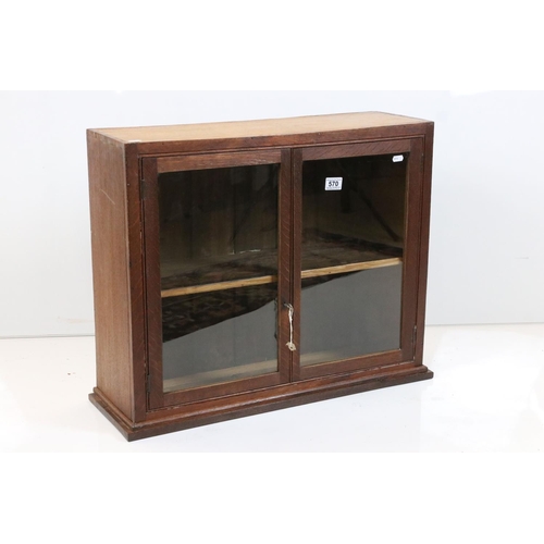 570 - Oak Wall Cabinet, the two glazed doors opening to shelf, with key, 72cm high x 57cm high