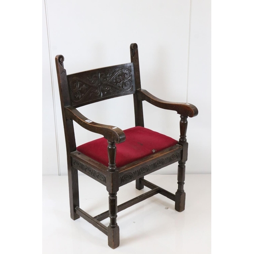 578 - In the manner of Liberty of London, Gothic Revival Oak Elbow Chair with carved back rail and upholst... 