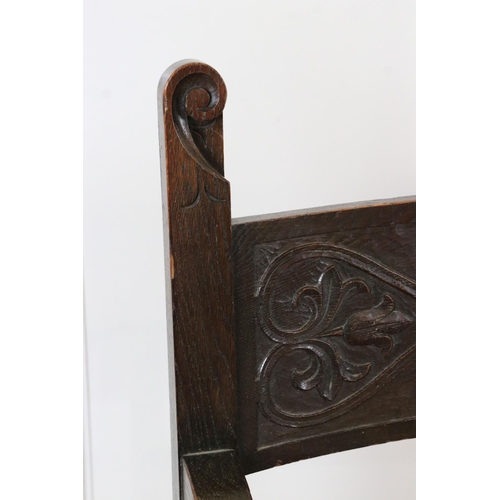 578 - In the manner of Liberty of London, Gothic Revival Oak Elbow Chair with carved back rail and upholst... 