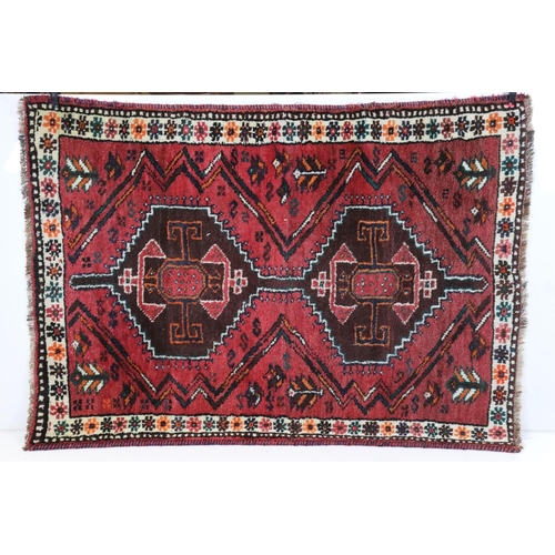 582 - Eastern Red Ground Rug with geometric pattern within a shallow border, approximately 145cm x 109cm