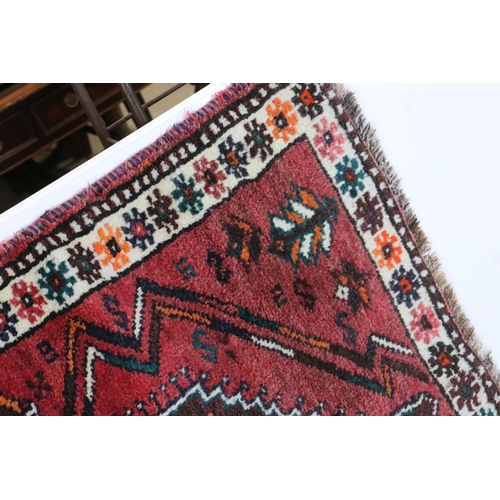 582 - Eastern Red Ground Rug with geometric pattern within a shallow border, approximately 145cm x 109cm