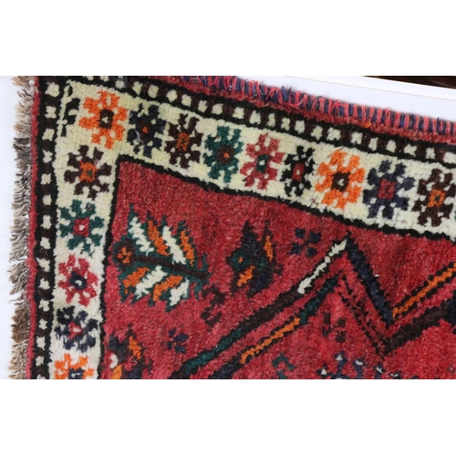 582 - Eastern Red Ground Rug with geometric pattern within a shallow border, approximately 145cm x 109cm