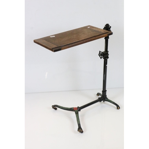 585 - Victorian Reading Table, the folding oak rectangular top held on a painted cast iron adjustable base... 