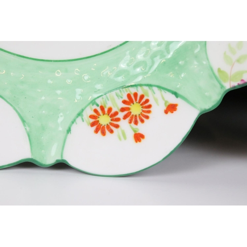 21 - Aynsley 1930's ' Flower Handle ' Trio, each piece hand painted with panels of flowers on a green gro... 