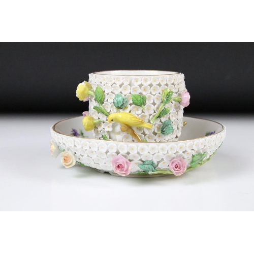 80 - Meissen flower encrusted tumbler cup, applied with canaries, on a circular saucer, chipped to unders... 