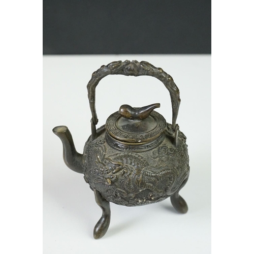 141 - Pair of Chinese bronze miniature kettles with swing handles and lids, the bodies cast with dragons, ... 