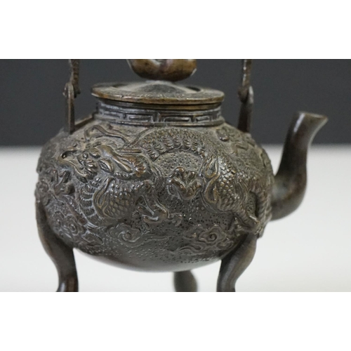 141 - Pair of Chinese bronze miniature kettles with swing handles and lids, the bodies cast with dragons, ... 