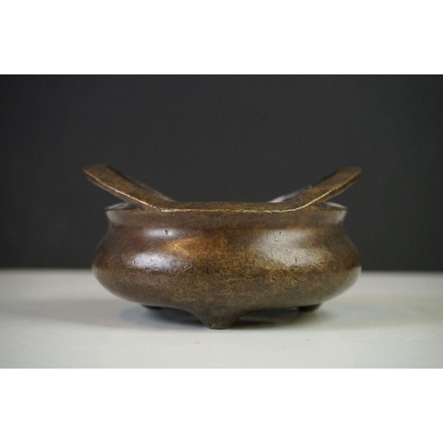 152 - Chinese Bronze Censer with two loop handles, raised on three tripod feet, sixteen character marked t... 