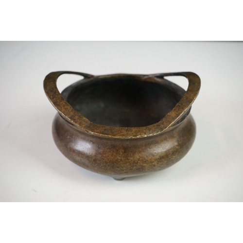 152 - Chinese Bronze Censer with two loop handles, raised on three tripod feet, sixteen character marked t... 