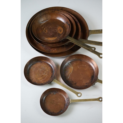 198 - Set of Seven Copper Graduating Frying Pans with brass handles, each pan stamped from 1 to 7, largest... 