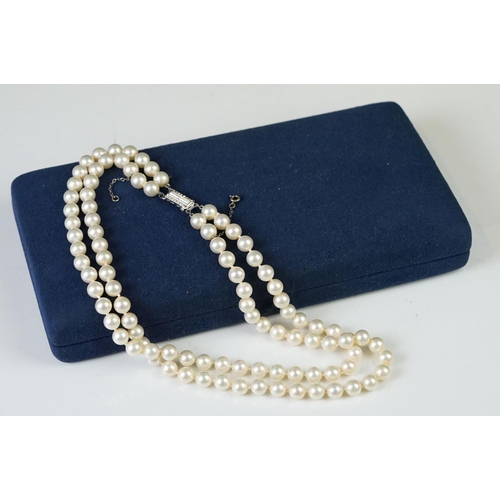 225 - A two row sautoir cultured pearl necklace with diamond set clasp.