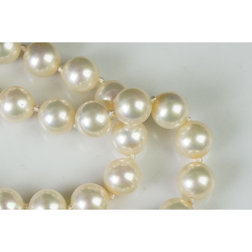 225 - A two row sautoir cultured pearl necklace with diamond set clasp.