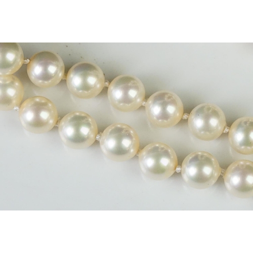 225 - A two row sautoir cultured pearl necklace with diamond set clasp.