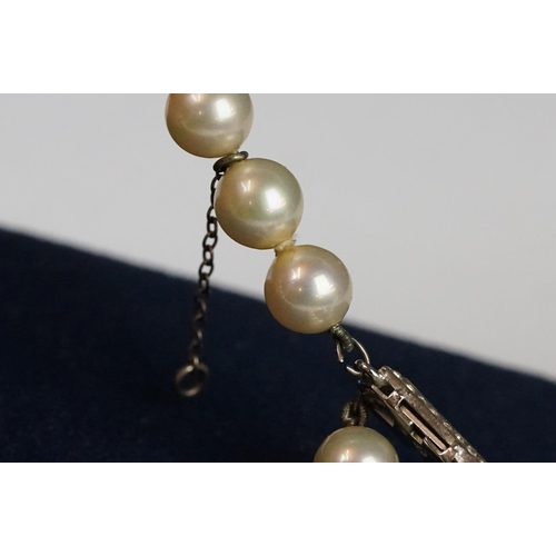 225 - A two row sautoir cultured pearl necklace with diamond set clasp.