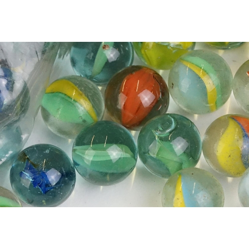 254 - A small collection of vintage glass marbles contained within two bags.