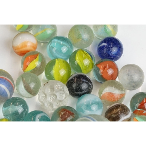 254 - A small collection of vintage glass marbles contained within two bags.