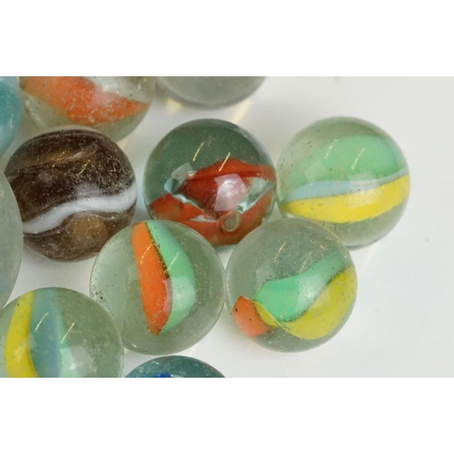 254 - A small collection of vintage glass marbles contained within two bags.