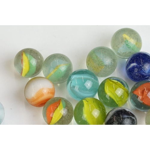 254 - A small collection of vintage glass marbles contained within two bags.