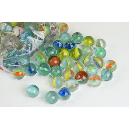 254 - A small collection of vintage glass marbles contained within two bags.