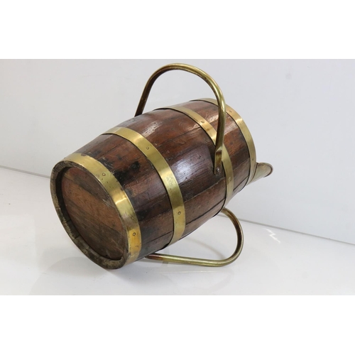 635 - Oak Coopered Barrel and Brass Bound Ale Jug with brass handle and stand, 59cm long x 43cm high