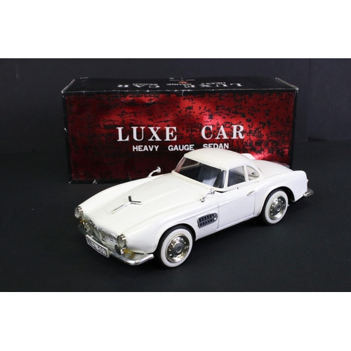 236 - Four boxed tin plate friction powered models to include Standard Sedan in white with pink hood, Leme... 