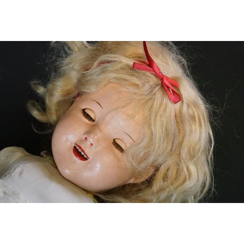 410 - Four circa early - mid 20th C plastic and composition dolls to include an Ideal Shirley Temple doll ... 