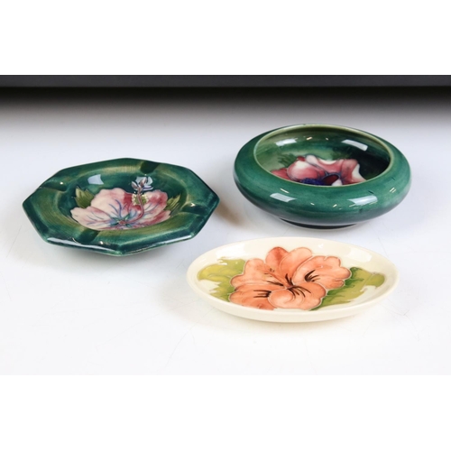58 - Moorcroft - A William Moorcroft ' Hibiscus ' pattern ashtray together with an ' Anemone ' astray and... 