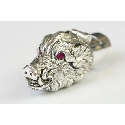219 - A silver plated whistle and vesta case in the form of a boars head with ruby eyes