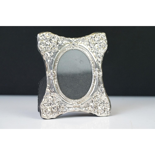 220 - A silver easel back picture frame with embossed decoration