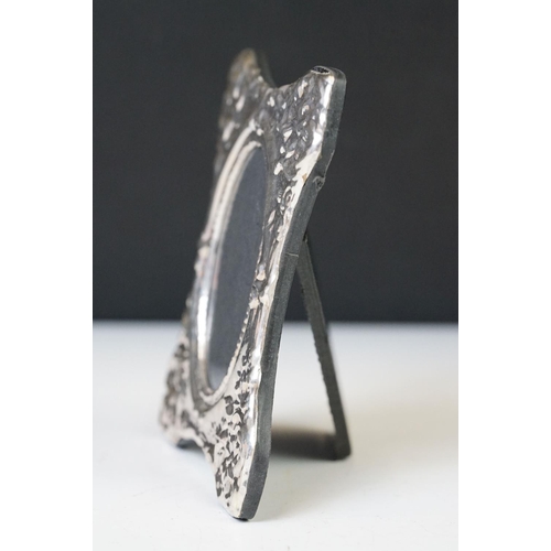 220 - A silver easel back picture frame with embossed decoration