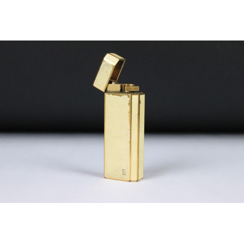 199 - A collection of four vintage pocket cigarette lighters to include Dunhill, Cartier and Christian Dio... 