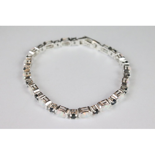 274 - A silver opal and sapphire line bracelet.