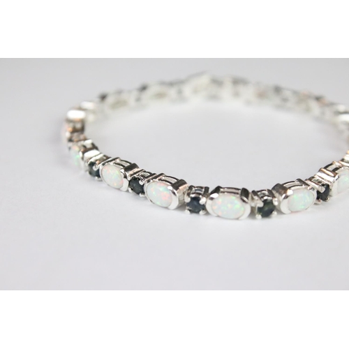 274 - A silver opal and sapphire line bracelet.