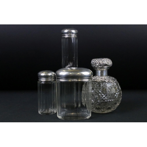 275 - A collection of three hallmarked sterling silver topped vanity jars together with a hallmarked silve... 