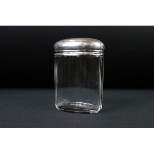 275 - A collection of three hallmarked sterling silver topped vanity jars together with a hallmarked silve... 