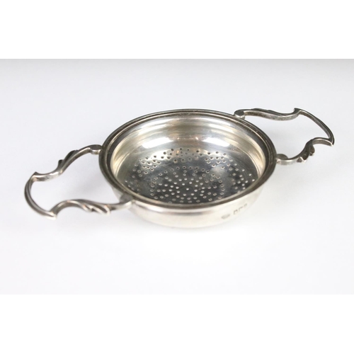 280 - A sterling silver twin handled tea strainer, assay marked for Sheffield.