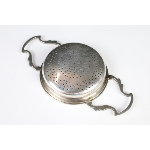 280 - A sterling silver twin handled tea strainer, assay marked for Sheffield.