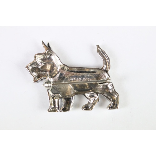 285 - A silver dog brooch set with a ruby eye.