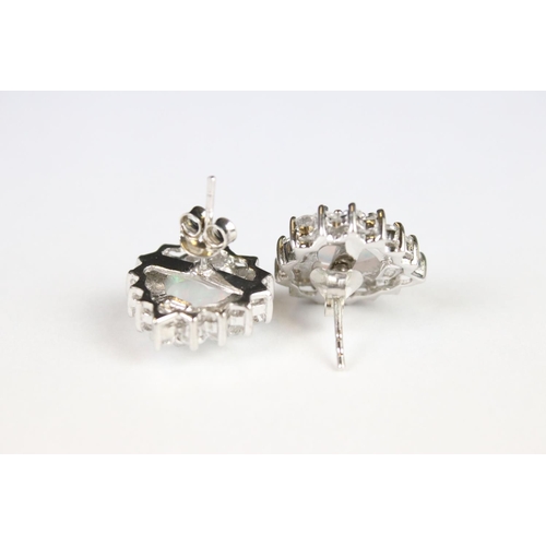 293 - A pair of silver CZ and opal panelled stud earrings.